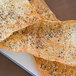 A rectangular white porcelain platter with sesame crackers on it.