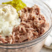 A bowl of Celebrity chunk light tuna with mayonnaise and pickles.
