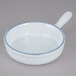 A white porcelain bowl with a blue speckled interior and a handle.