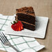 A slice of chocolate cake with strawberries on a 10 Strawberry Street Blue Speckled porcelain bread and butter plate.