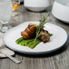 A 10 Strawberry Street Arctic Blue porcelain dinner plate with meat and green beans on it.