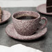 A cup of coffee on a Biseki Himalayan salt stoneware saucer with a slice of cake.