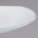 A white rectangular porcelain dinner plate with a speckled design on it.