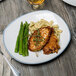 A 10 Strawberry Street Arctic Blue rectangular porcelain dinner plate with chicken, asparagus, and pasta on a table.