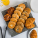 A 10 Strawberry Street granite porcelain platter with bagels, croissants, and orange juice on a table.