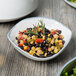 A close-up of a blue 10 Strawberry Street Arctic bowl filled with black bean and corn salad.