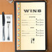 Menu paper with a southwest fiesta border design on a table with wine glasses and a knife and fork.
