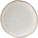 A white Tuxton china plate with brown specks.