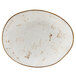 A white oval Tuxton China ellipse plate with brown specks.