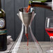 A Rabbit stainless steel wine funnel pouring red wine into a glass.