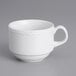 A white Tuxton China cup with a scalloped edge and handle.