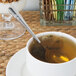 A Oneida stainless steel teaspoon in a cup of tea.