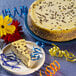 A Pellman chocolate chip cheesecake on a plate with flowers and streamers.