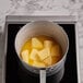 A pot of Minerva Dairy Sea Salted Butter on a stove with yellow liquid.