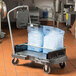A Rubbermaid ice tote cart with two blue ice totes on it.