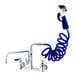 A T&S wall mounted pet grooming faucet with a blue coiled hose attached.