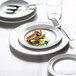 A white Arcoroc porcelain side plate with food on it.