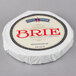 A round white wheel of Eiffel Tower Brie cheese with a blue and red label.