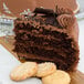 A slice of Pellman Triple Chocolate Cake with cookies on a cutting board.