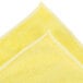 A yellow Unger SmartColor medium-duty microfiber cloth with white edges folded in half.