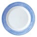 An Arcoroc white opal glass lunch plate with blue brush strokes in a striped design.
