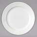A close-up of an Arcoroc white porcelain salad plate with a wavy design.