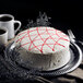 A Pellman strawberry cake with white icing and red lines on a plate with a fork.