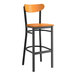 A Lancaster Table & Seating black bar stool with a cherry wood seat and back.