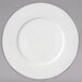 A white Arcoroc porcelain service plate with a circular wavy design.