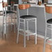 A group of Lancaster Table & Seating bar stools with black vinyl seats and antique walnut backs.