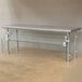 A silver metal table with a stainless steel shelf and glass panels.