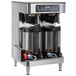 A Bunn stainless steel automatic coffee brewer with two coffee containers on top.