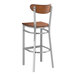 A Lancaster Table & Seating metal bar stool with a wooden seat and back.