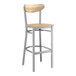 A Lancaster Table & Seating bar stool with a wooden seat and back and metal frame.