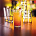 A close-up of a customizable beverage glass filled with orange liquid and a lime slice.