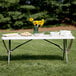 A Lancaster Table & Seating granite white folding table with food on it outdoors.