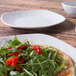 An Elite Global Solutions off white melamine square plate with a salad on it on a table.