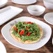 A white square Elite Global Solutions Tenaya melamine plate with a salad on it.