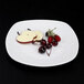 An off white Elite Global Solutions square melamine plate with fruit and berries on it.