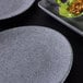 An Elite Global Solutions Tenaya granite stone melamine plate with food on it.
