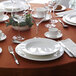 A table set with white Chef & Sommelier bone china plates and glasses.