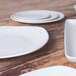 An Elite Global Solutions off white melamine plate on a white surface.