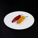 An off white Elite Global Solutions melamine plate with two chili peppers.