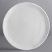 An off white Elite Global Solutions round melamine plate with a spiral pattern.
