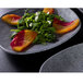 An Elite Global Solutions Tenaya granite stone square melamine plate with salad, peaches, and cheese on it.