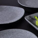 A Elite Global Solutions granite stone square melamine plate with lettuce on it.