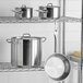 A stainless steel rack holding Vigor SS1 Series stainless steel pots and pans.