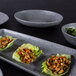 A tray of Elite Global Solutions granite stone melamine plates with a bowl of greens on a table.