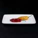 An off white rectangular melamine plate with two chili peppers.