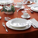A table set with white Chef & Sommelier bone china bowls, plates, and glasses.